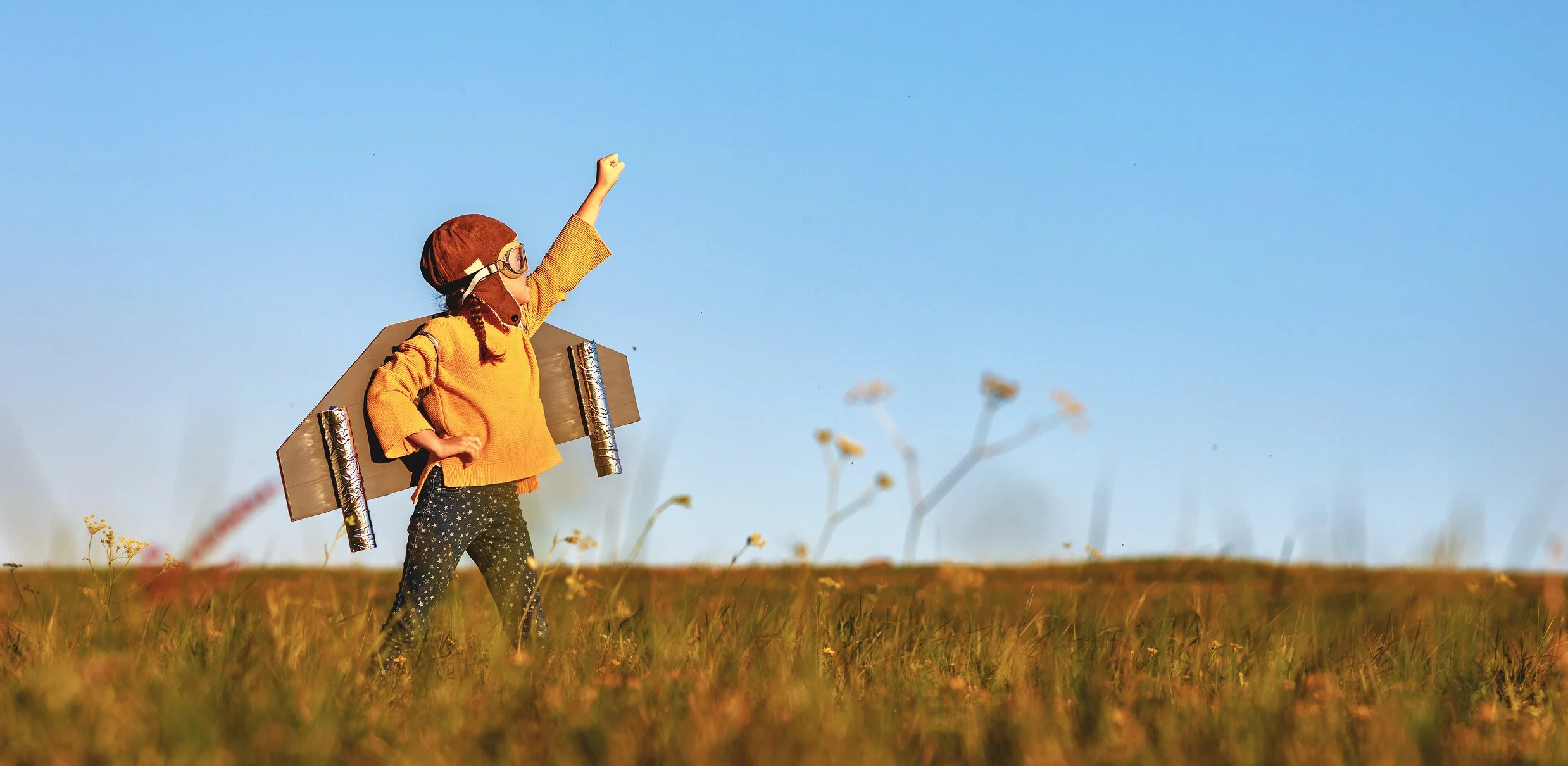 Young boy wearing cardboard wings and imagining he can fly, representing the possibilities of a smarter way to run a business.