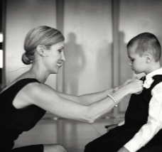 Celebrant helping a young boy adjust his bow tie.