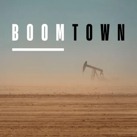 A large oil pumpjack in a hazy, desert landscape with the text 'BOOMTOWN' at the top.