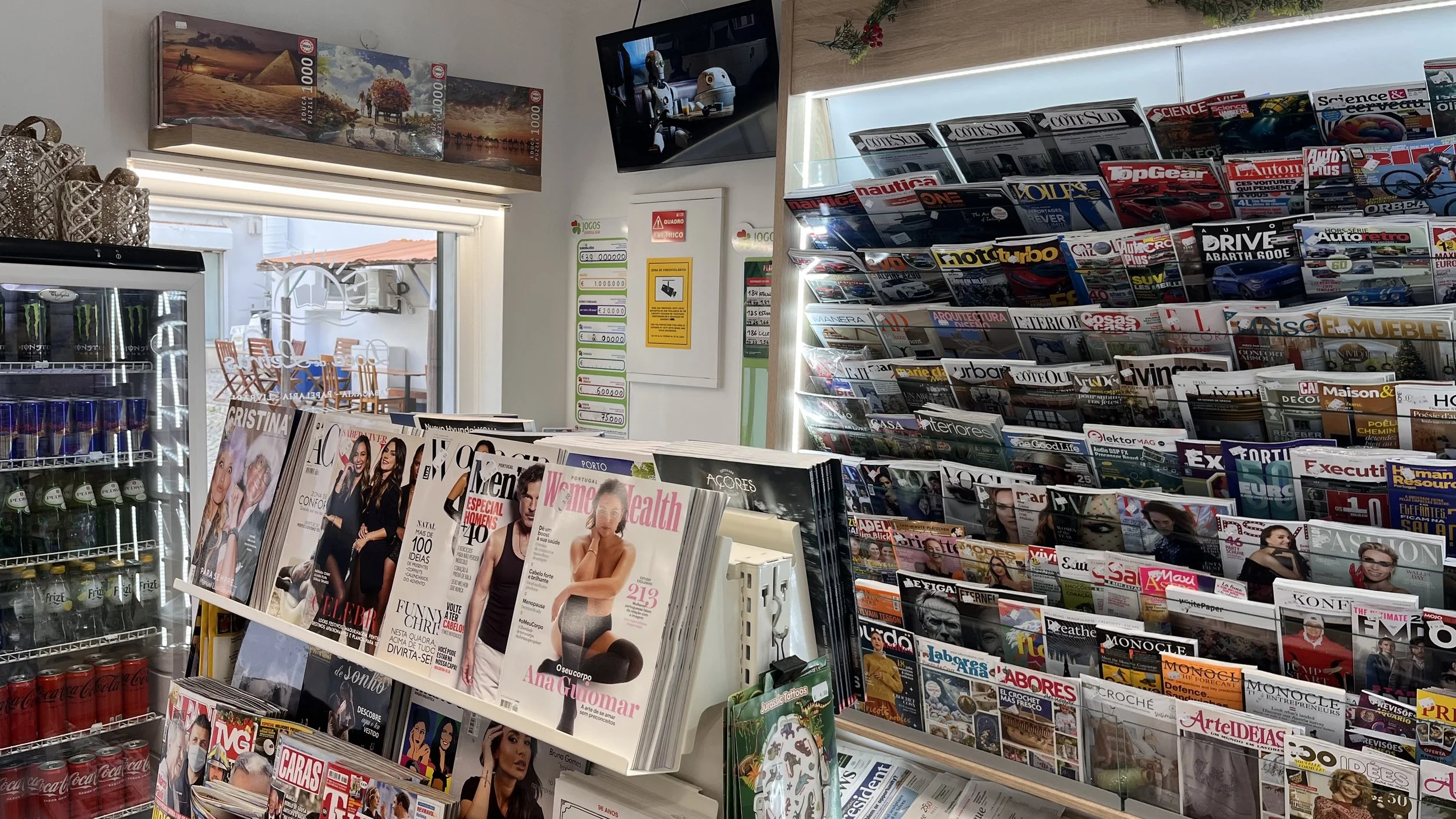 Prateleira com revistas de assuntos diversos, como moda, desporto e tecnologia,  numa loja de jornais e revistas.