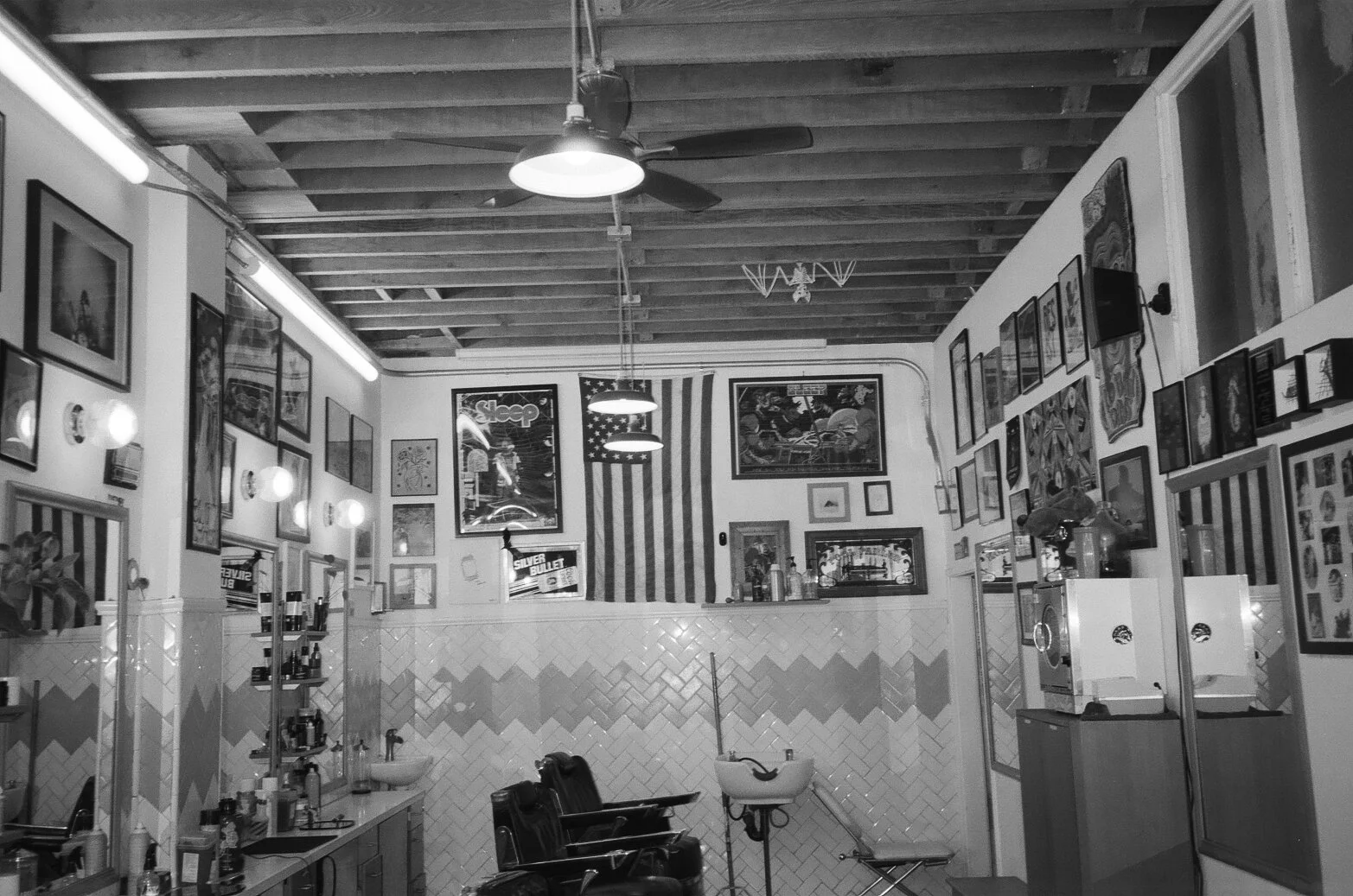 Interior of a vintage barber shop with chairs, mirrors, and wall art.
