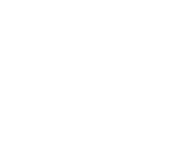 A hand holds a hair clipper near a pair of scissors.