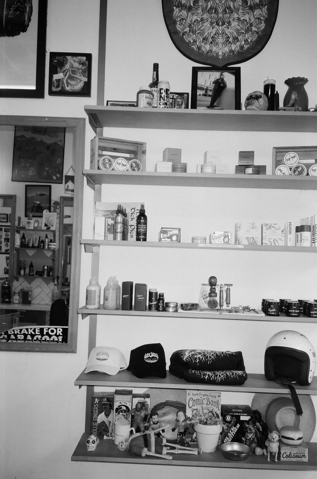 A black and white shelf display with various small objects, books, and decorative items in a store or cafe setting.