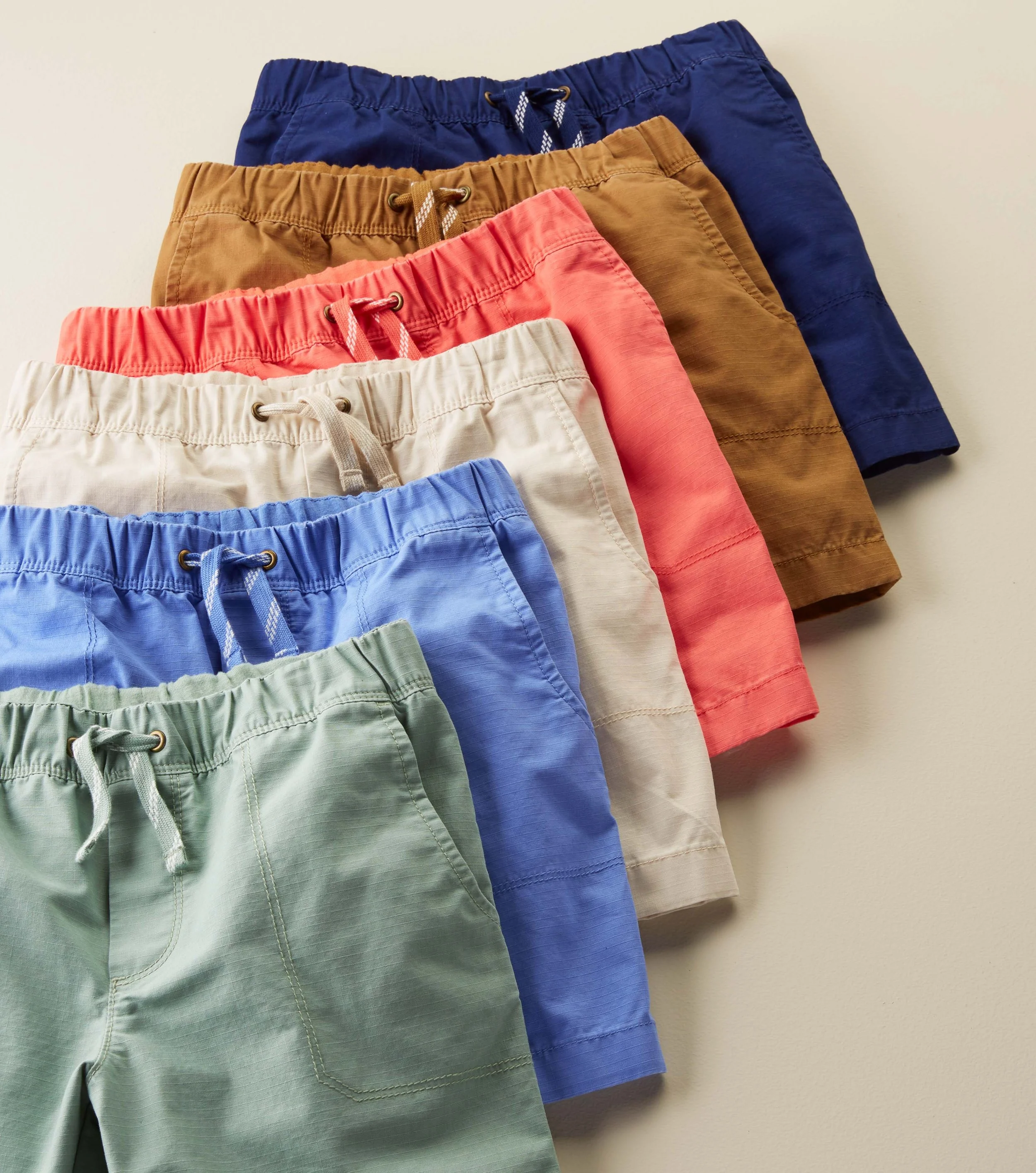 Color run of shorts in different colors, featuring elastic waistbands and drawstrings.