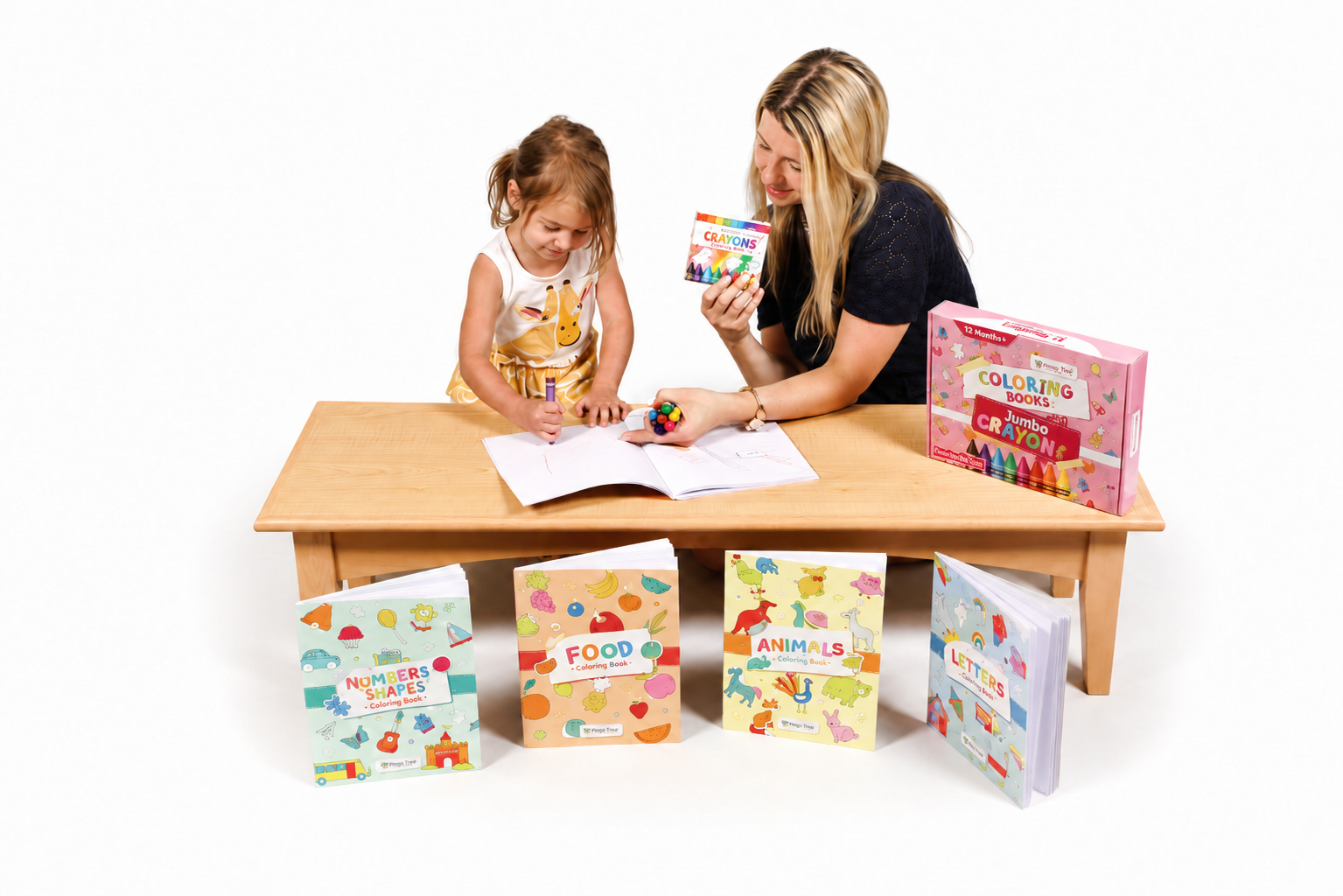 Uma mulher e uma criança pequenas estão na mesa de madeira, com livros de colorir e giz de cera ao redor, participando de uma atividade de desenho.