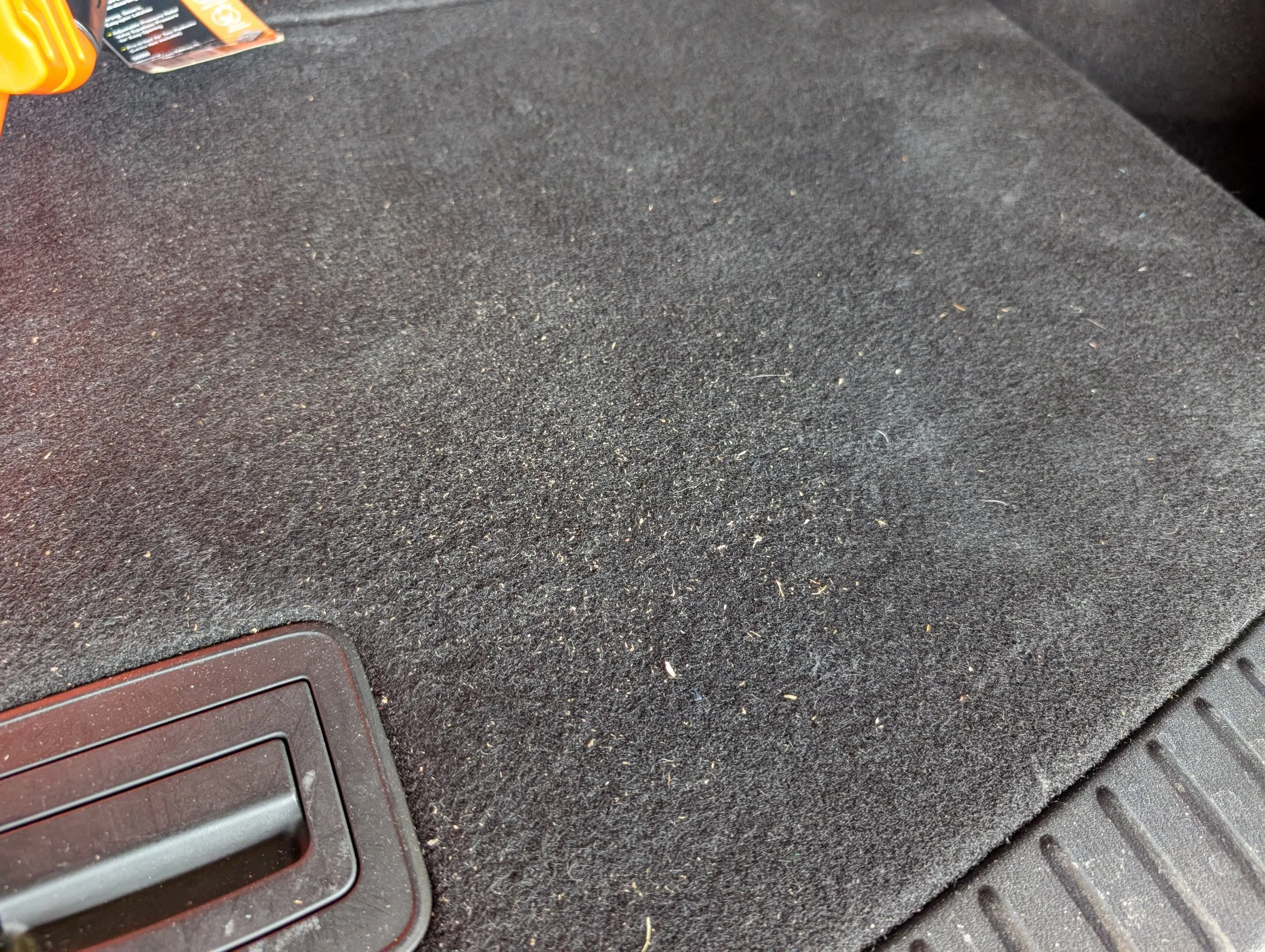 Close-up of a section of a computer keyboard on a black textured surface with some dust particles, near the bottom left corner.