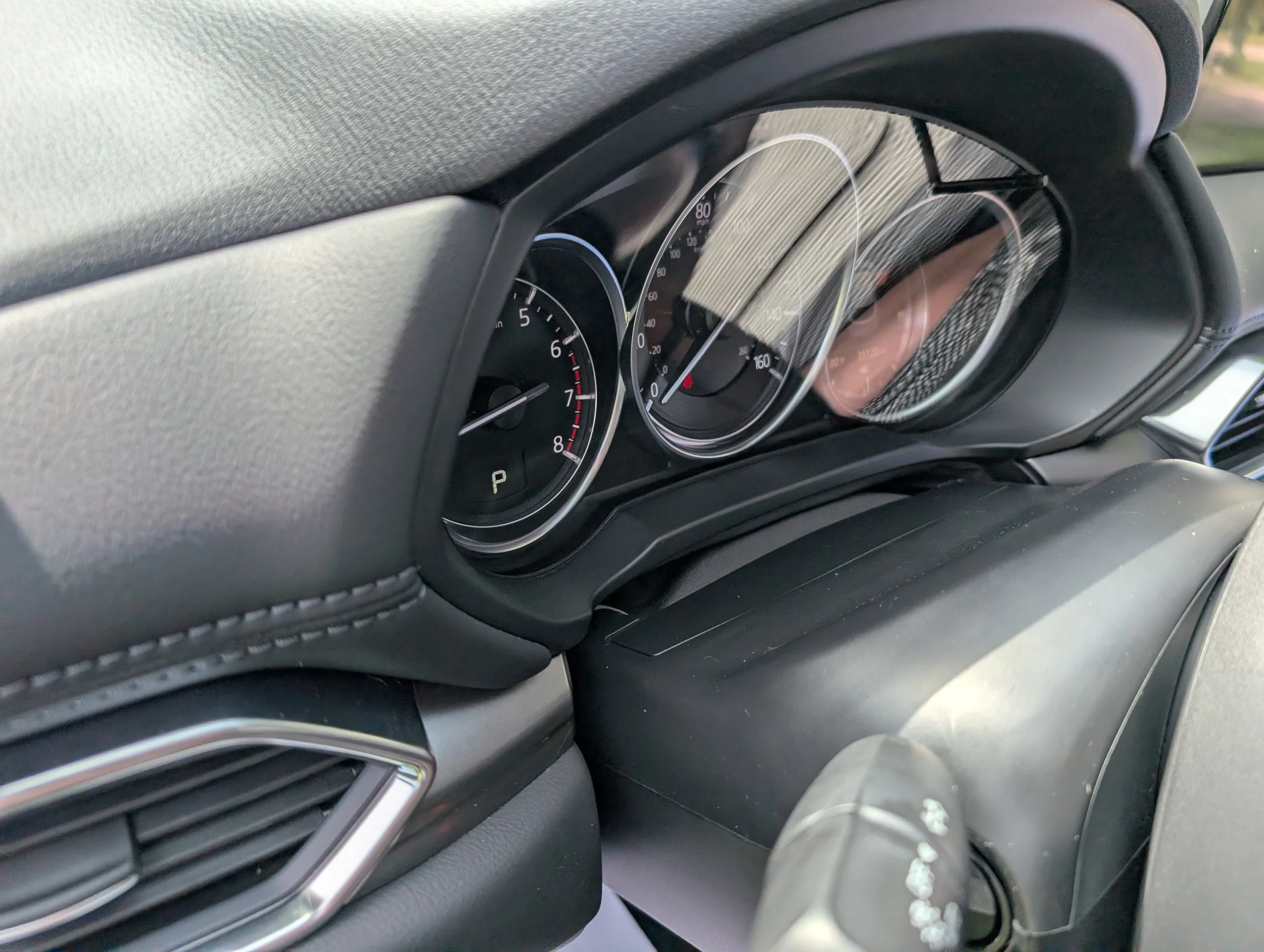 Close-up of a car dashboard showing speedometer, tachometer, and other gauges.