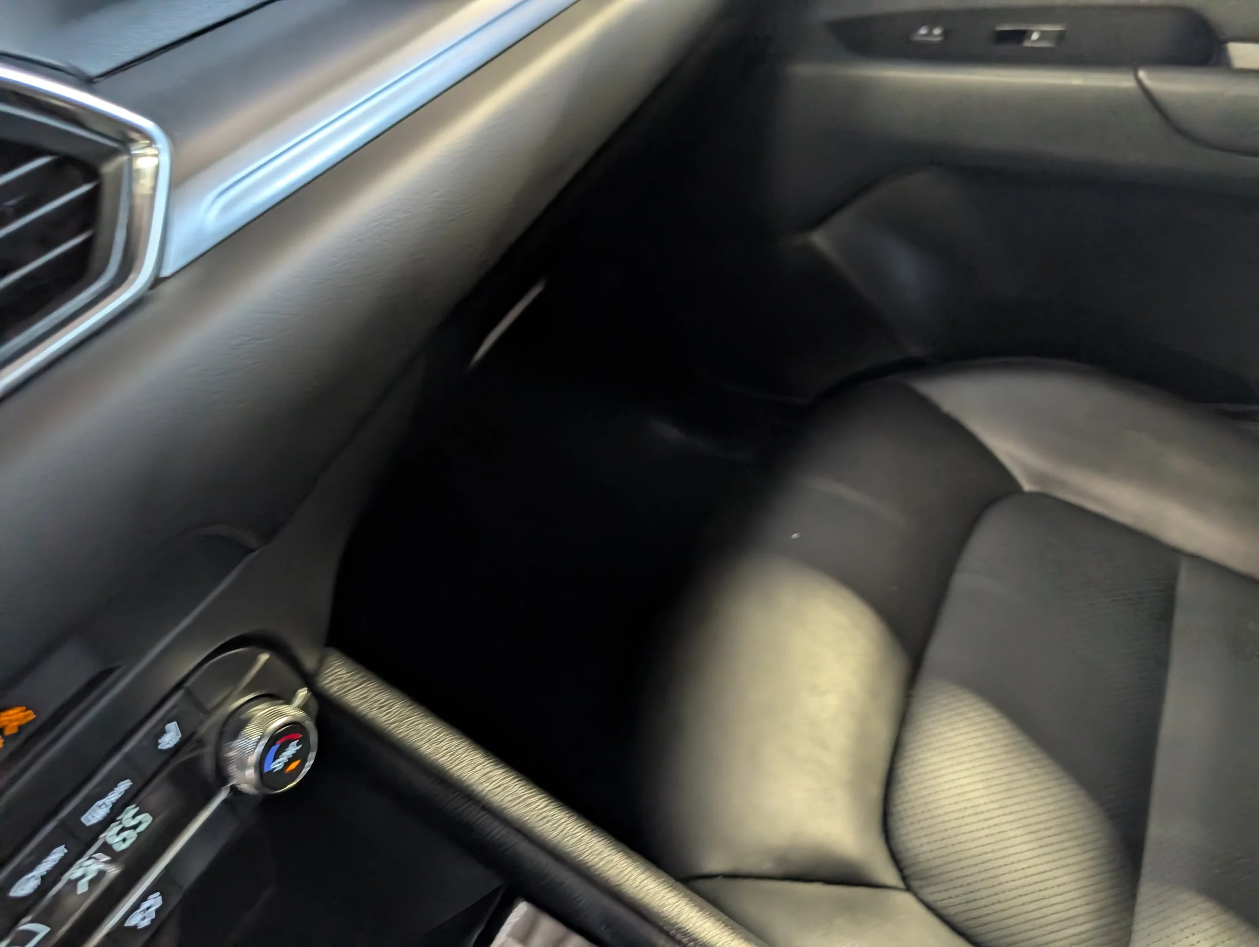 The interior of a car showing the dashboard, air vents, climate control system, and the passenger side with some of the seat visible.