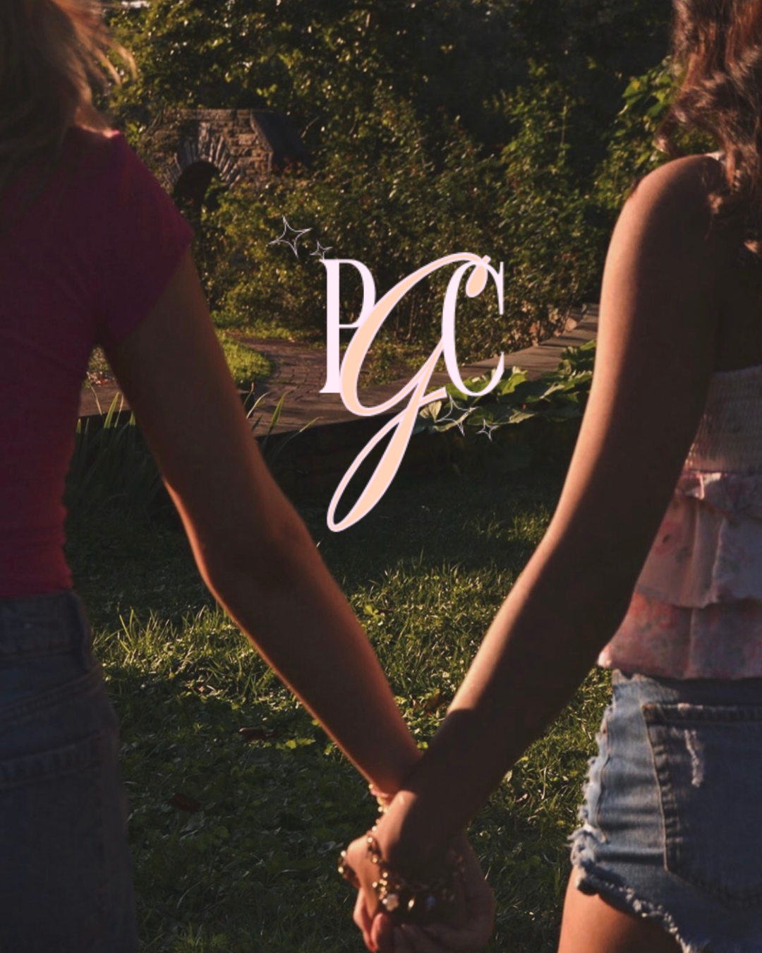 Two women holding hands outside in a garden during sunset, with the initials 'GC' and decorative stars overlaid in the center.