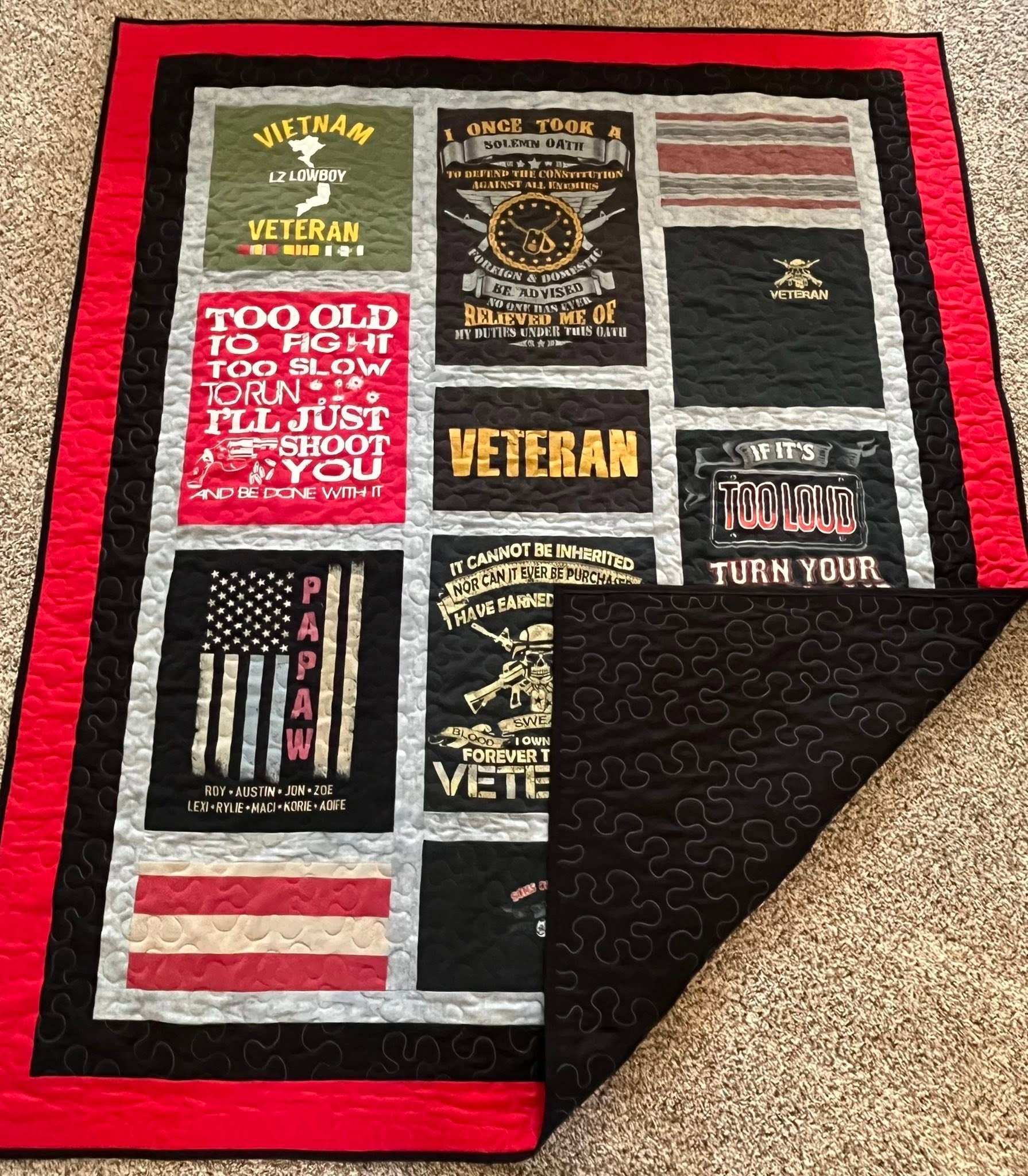 A quilt with various military and veteran-themed patches and messages, including the American flag, a skull with cross rifles, and the word 'VETERAN' in large letters.