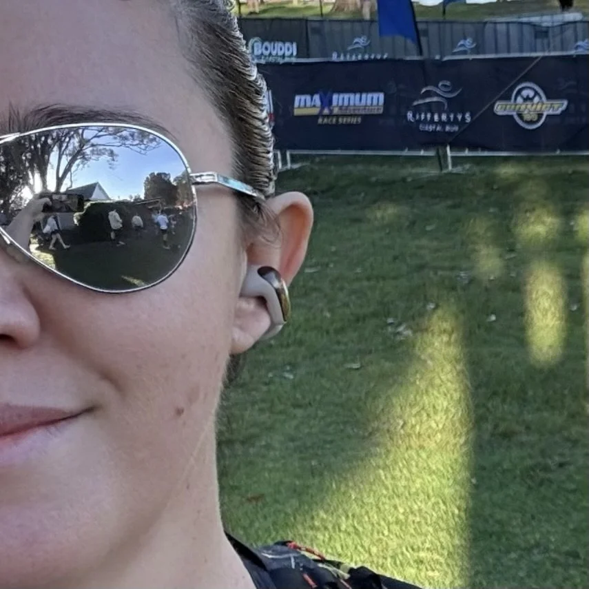 Wearing the open earbud on a run, sunglasses on