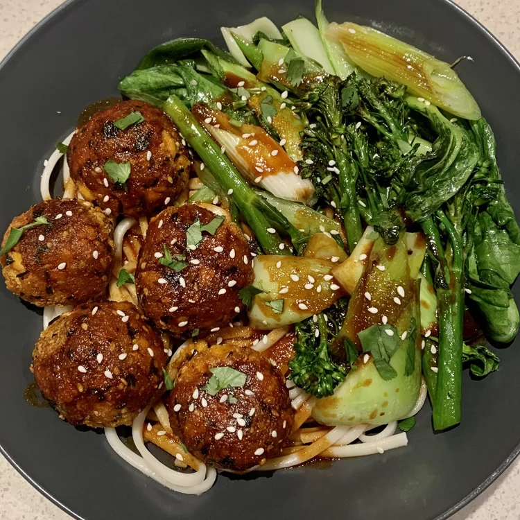 Plant-based meatballs with noodles and greens