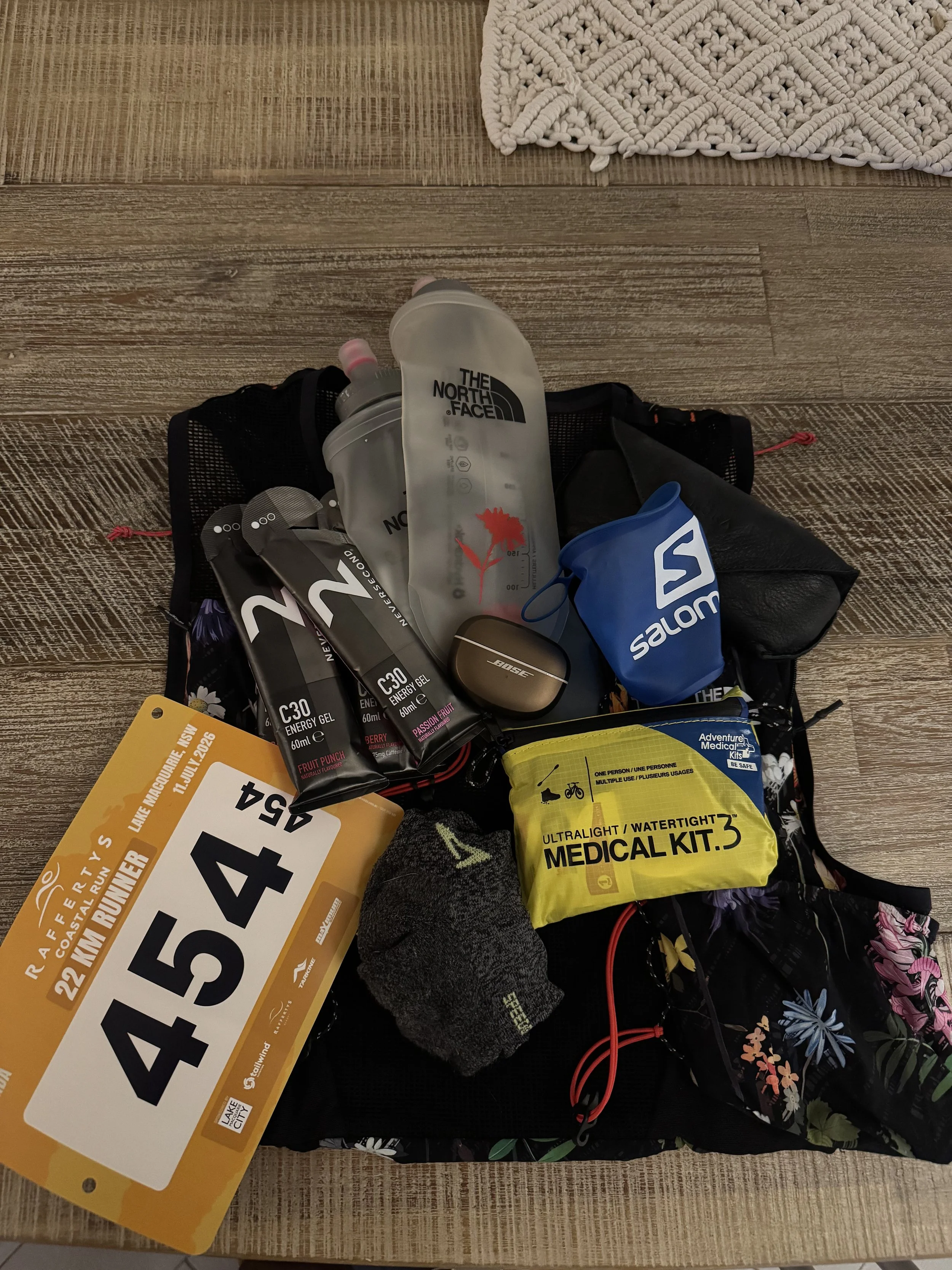 Kit flatlay: bib, C30 gels, soft flask, medical kit and vest