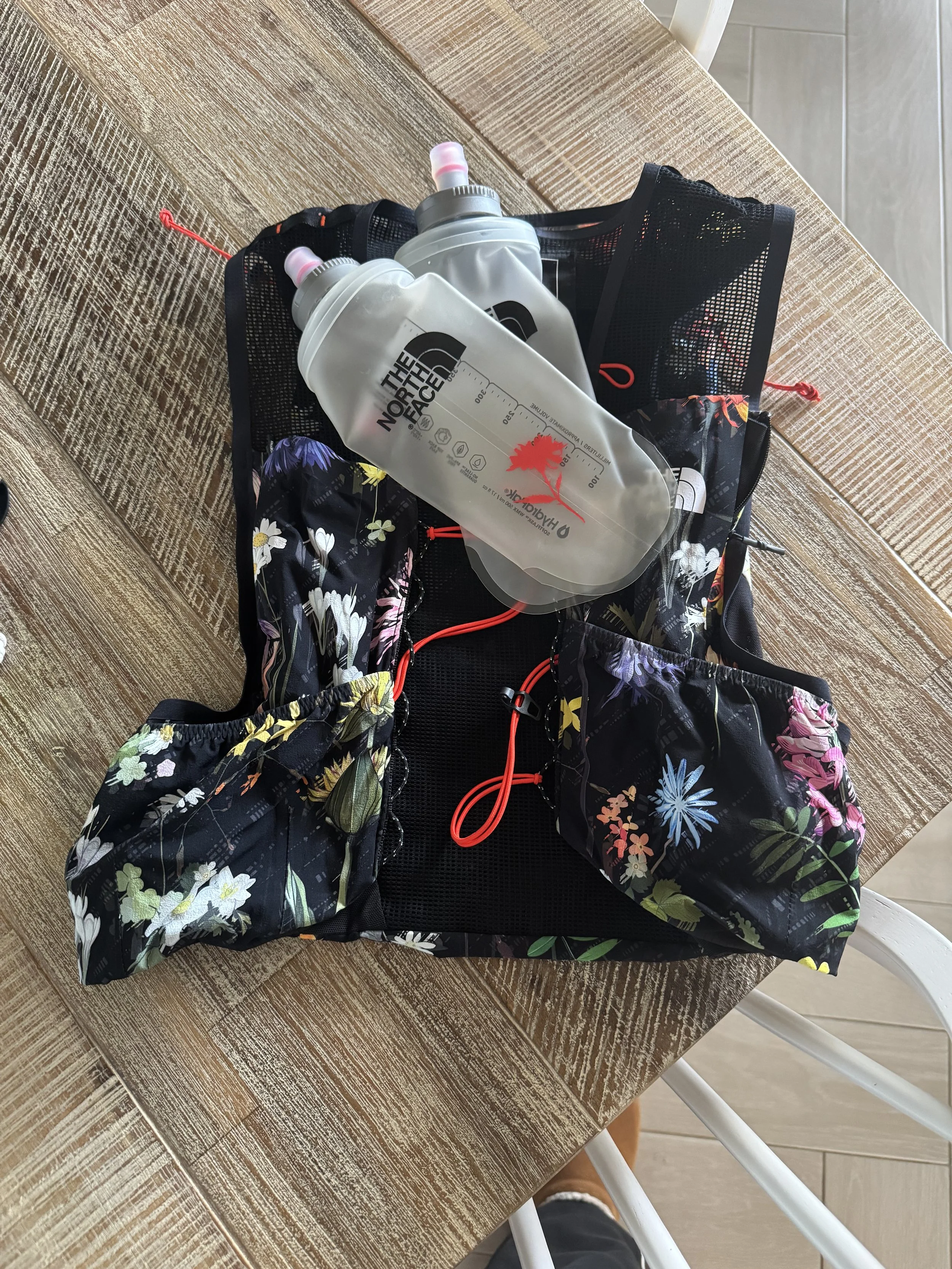 The vest laid flat with both front flasks and floral print