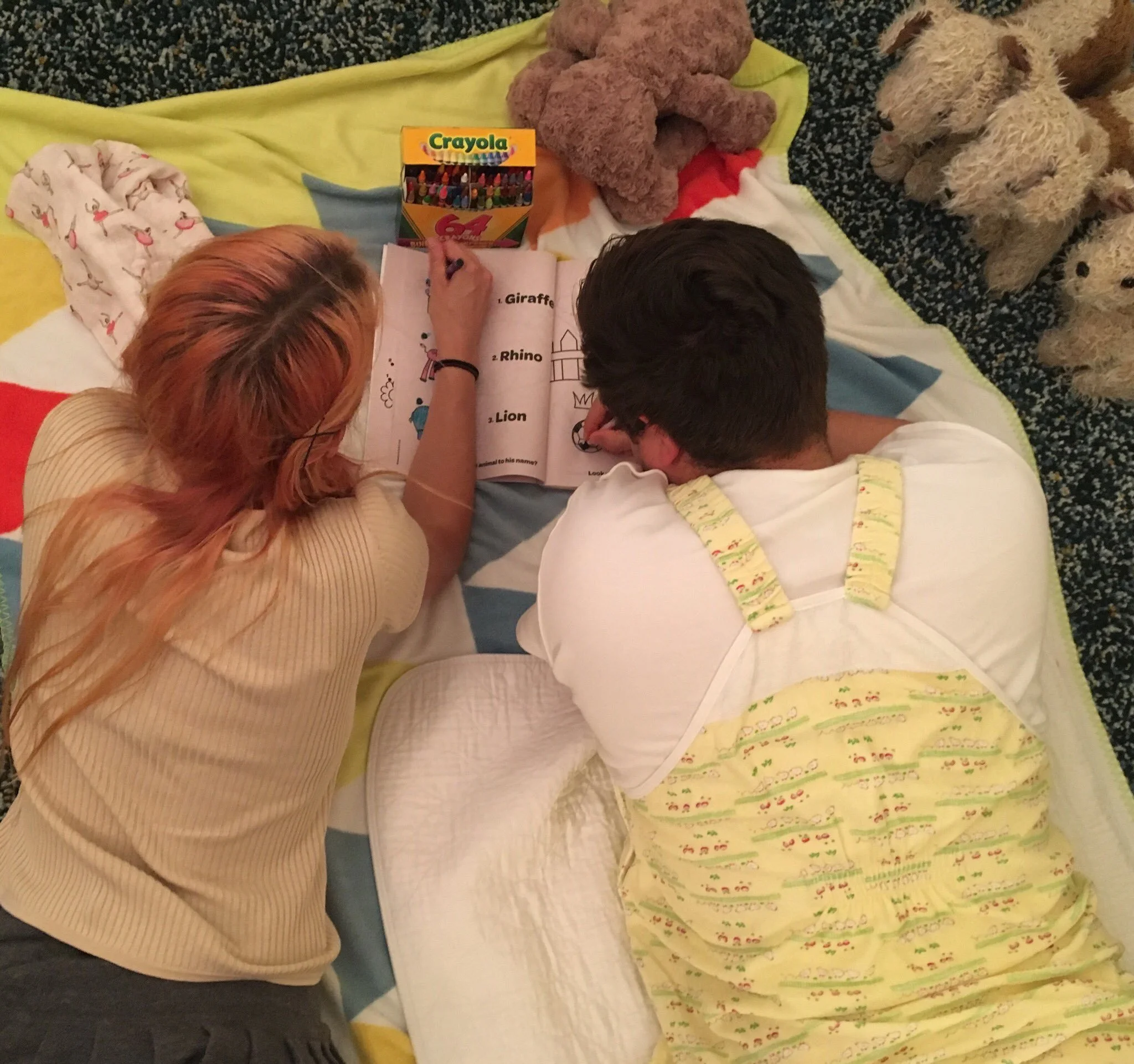 An older child helps baby color.