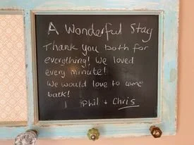 A chalkboard with a message thanking guests, signed by Phil and Chris.
