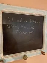 Blackboard with handwritten message: 'I had a lovely stay thanks Marianne'.