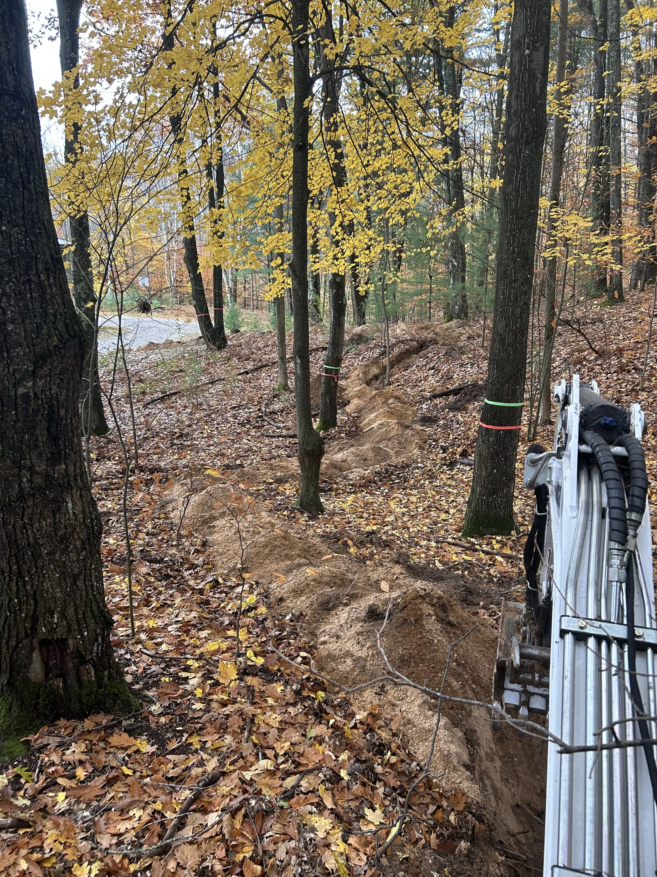 Oak wilt root-separation trench being excavated through a wooded property in Northern Michigan.