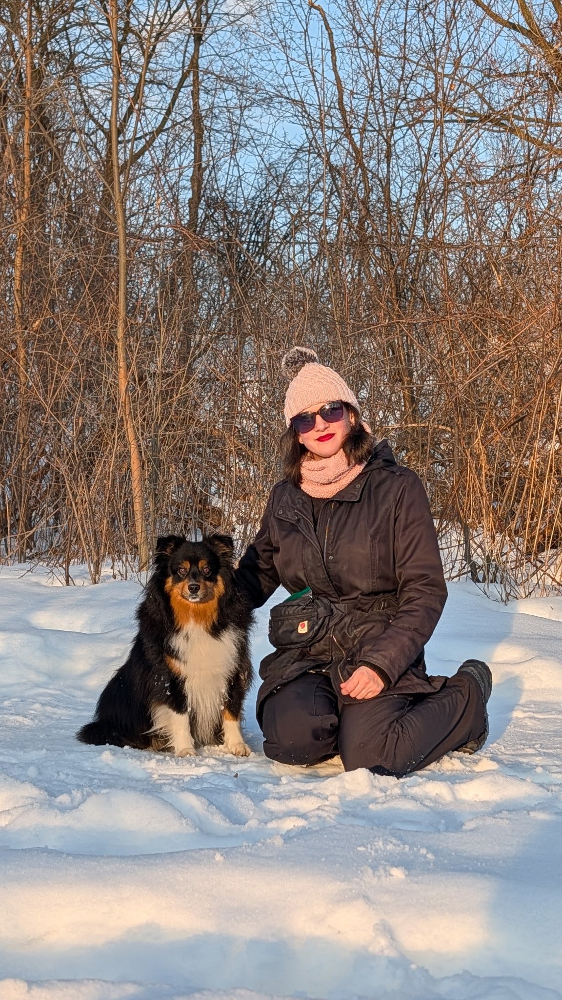 A photo of Sarony Blacklock with her dog Bear Bear out in the snow on a sunny afternoon in winter