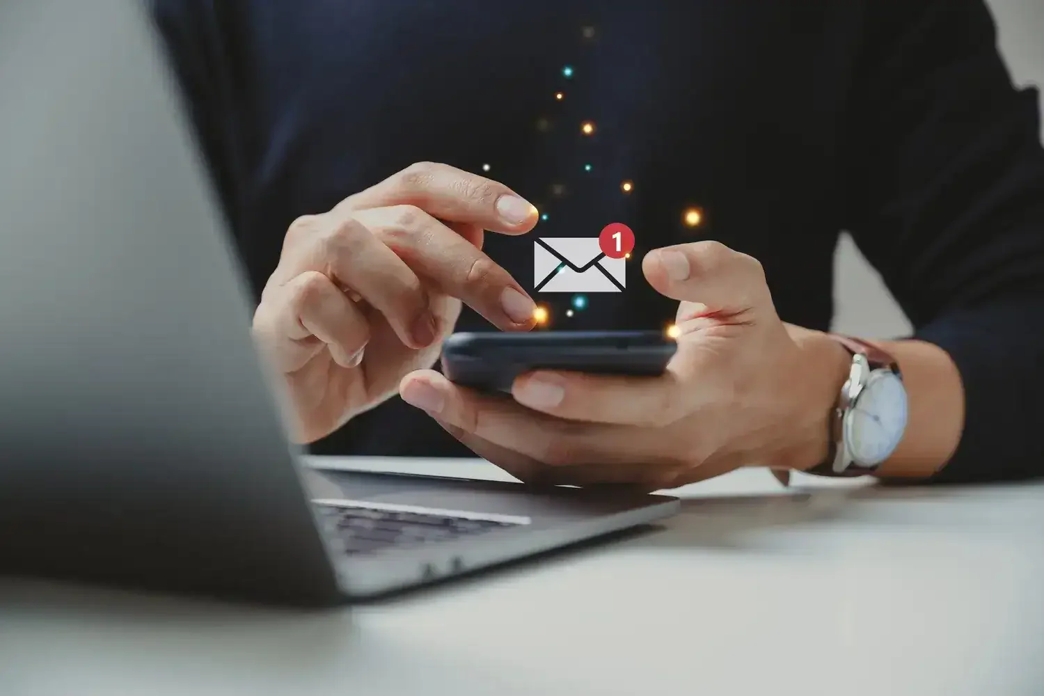 Bir kişinin elleriyle akıllı telefon kullanırken, ekranda bir mesaj bildirimi ikonu görünmekte.