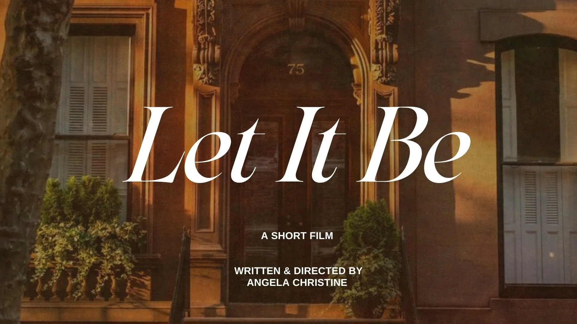 Title screen for a short film titled "Let It Be" showing a photo of a building with a large wooden door and the number 75 above it, with some trees and a lamp post in front, and the text "A Short Film" and "Written & Directed by Angela Christine".