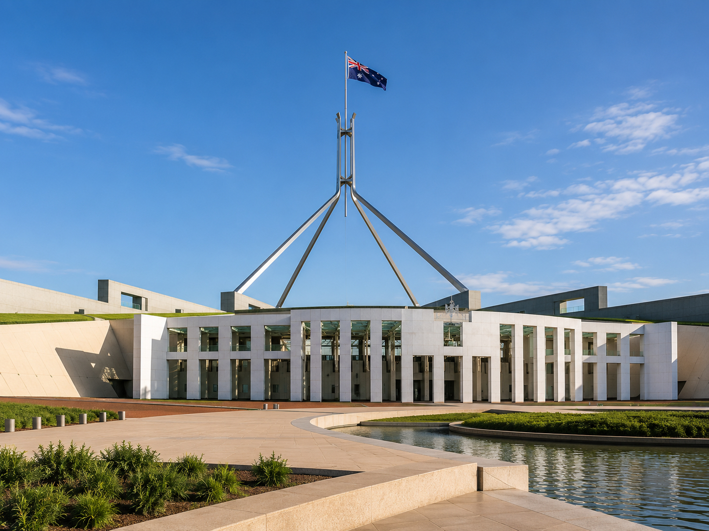 The Australian Parliament House with a flagpole and flag of Australia, under a clear blue sky.