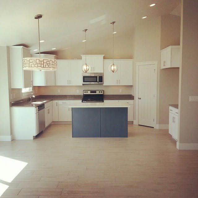 Bright custom kitchen with recessed ceiling lights and pendant lighting over the island