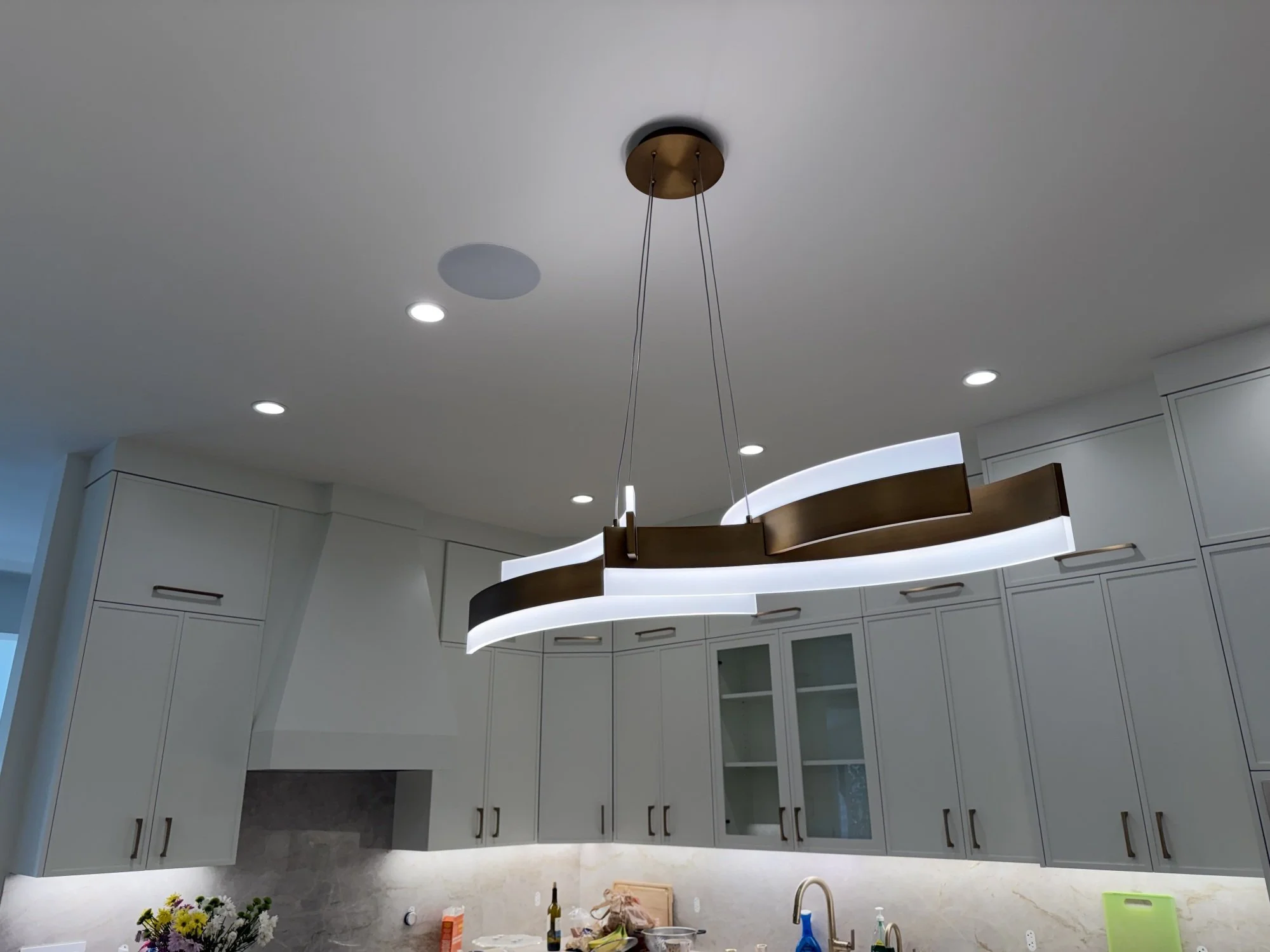 Contemporary kitchen lighting with recessed lights and suspended island fixture