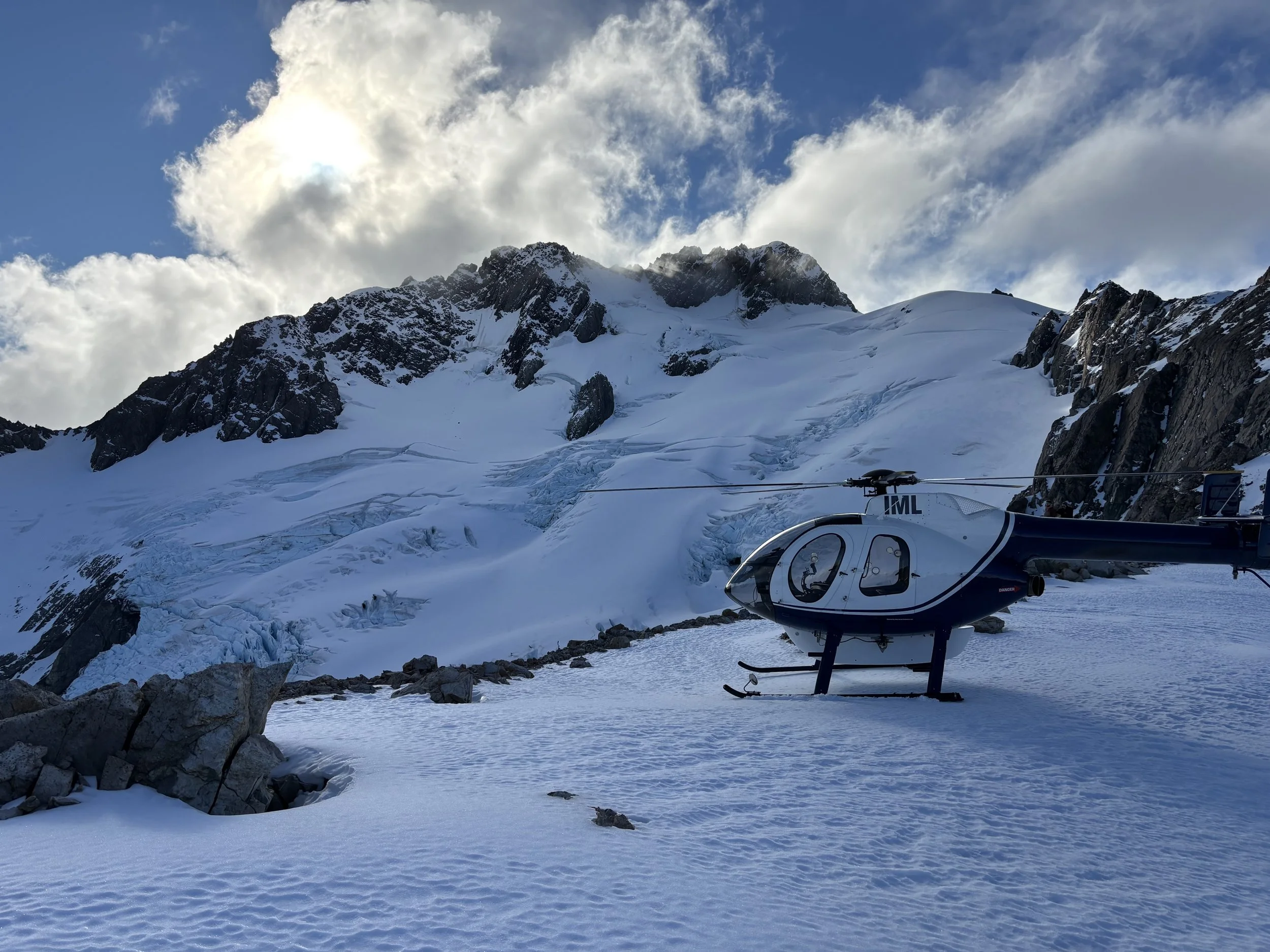 A helicopter landed at Kahutea Glacier surrounded by snow.
