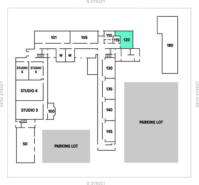 Building floor plan with numbered rooms, two parking lots, two studios, a gray shaded area, and a highlighted room 120 in light blue.