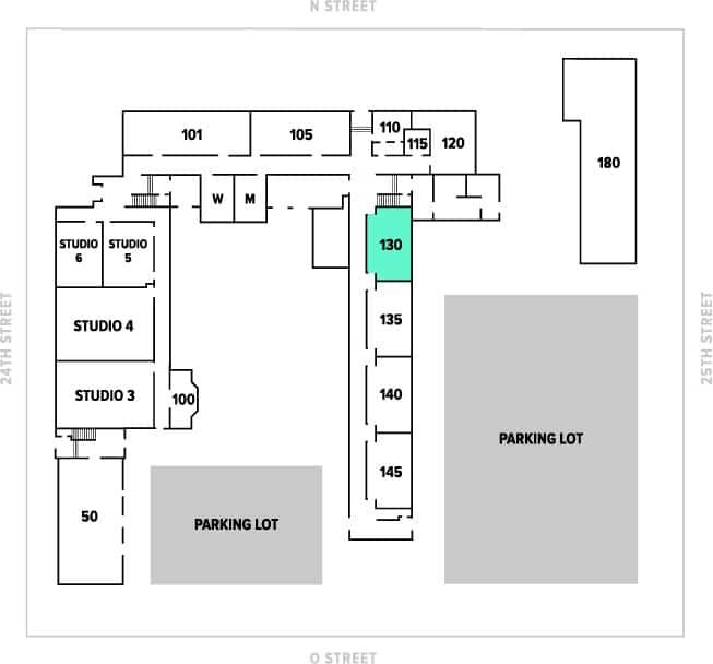 Floor plan of a building with numbered rooms, studios, and parking lots. The building includes studios 3-6, rooms 100-145, and various other numbered rooms, with parking lots on the south and east sides.