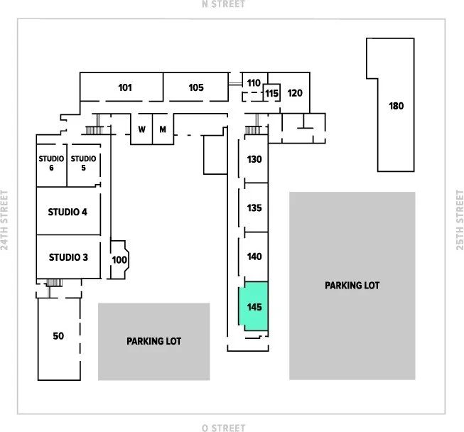 A building floor plan showing numbered rooms, studios, parking lots, and streets surrounding the building.
