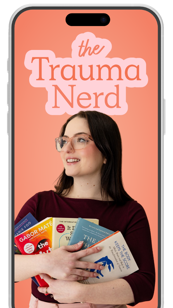 A woman with glasses holding multiple books, smiling, in front of a peach-colored background displaying the text 'the Trauma Nerd'.