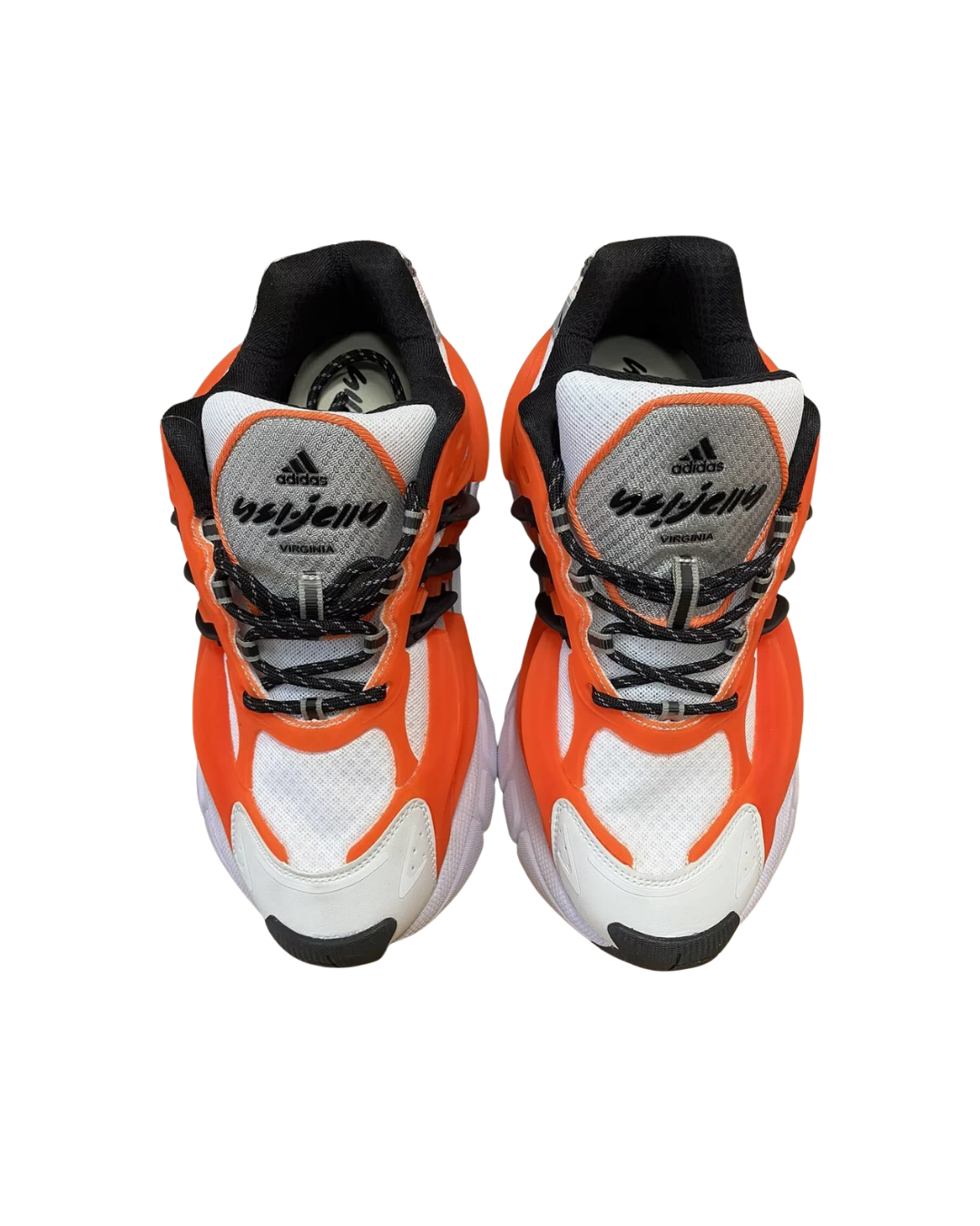 Front view of a pair of Pharrell x adidas Adistar Jellyfish sneakers in orange, white, and black