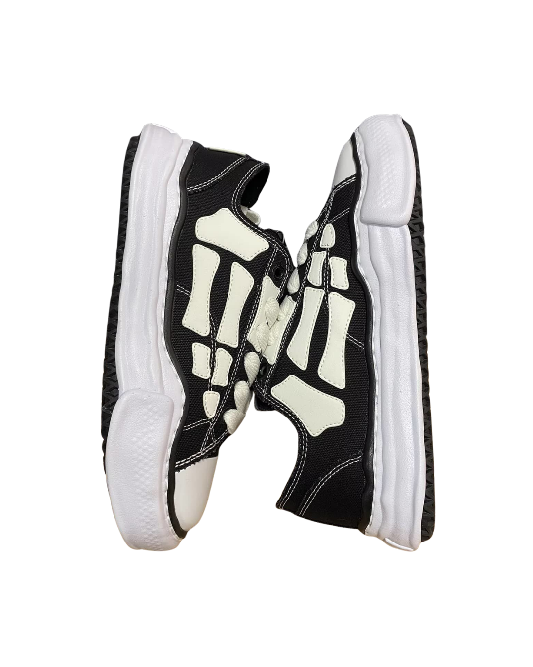 Front view of the AMIRI x MMY Bones sneaker pair facing each other, showing the black and cream skeleton paneling