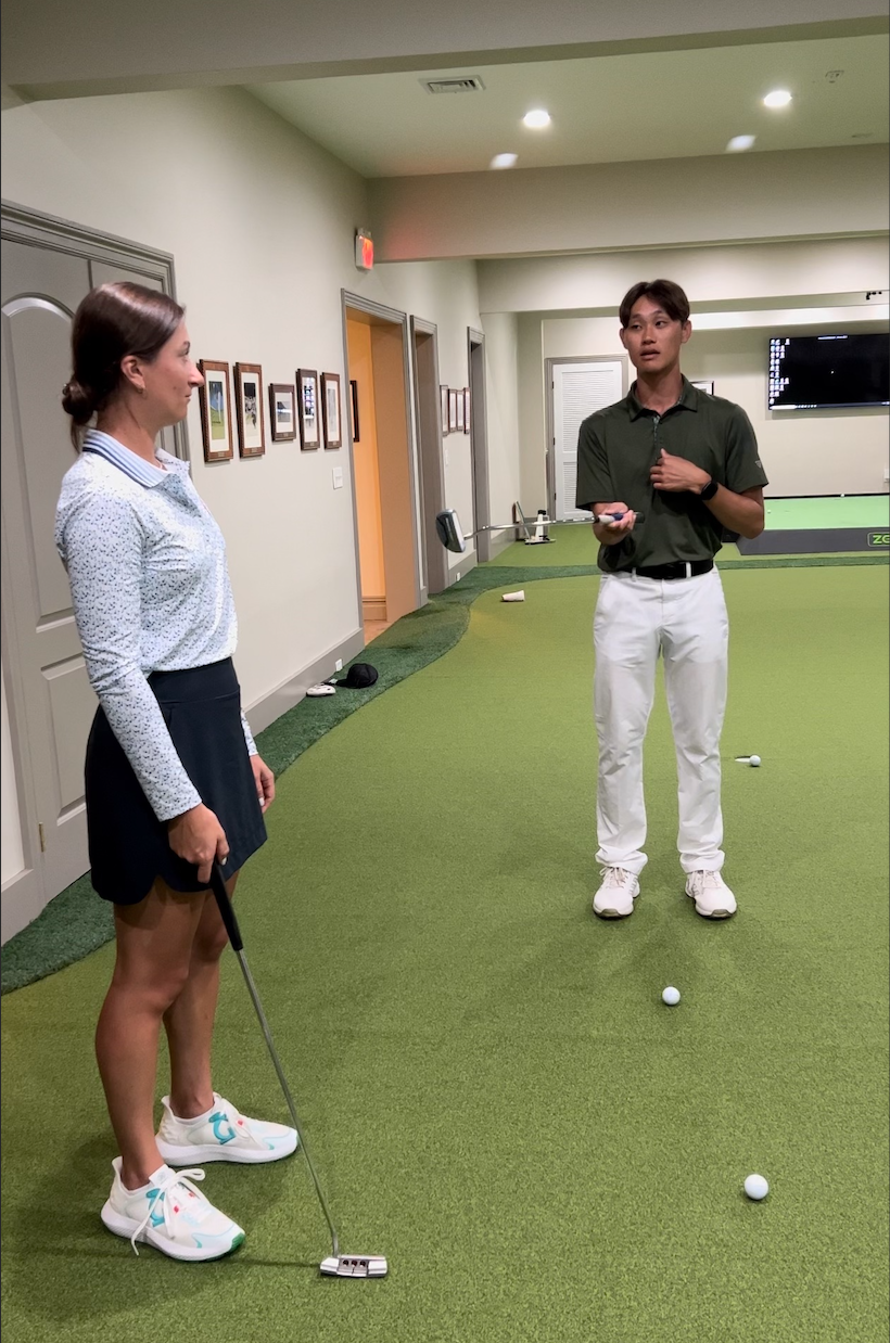 Robert Lee helping Christina Parsells, USGA champion, in an indoor putting green with her putting stroke at Baltusrol Golf Club
