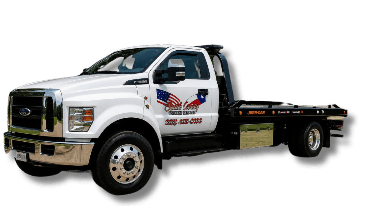 White tow truck with a flatbed, featuring decals of the American and Texas flags, and the text 'South County Wrecker Service' with a phone number.