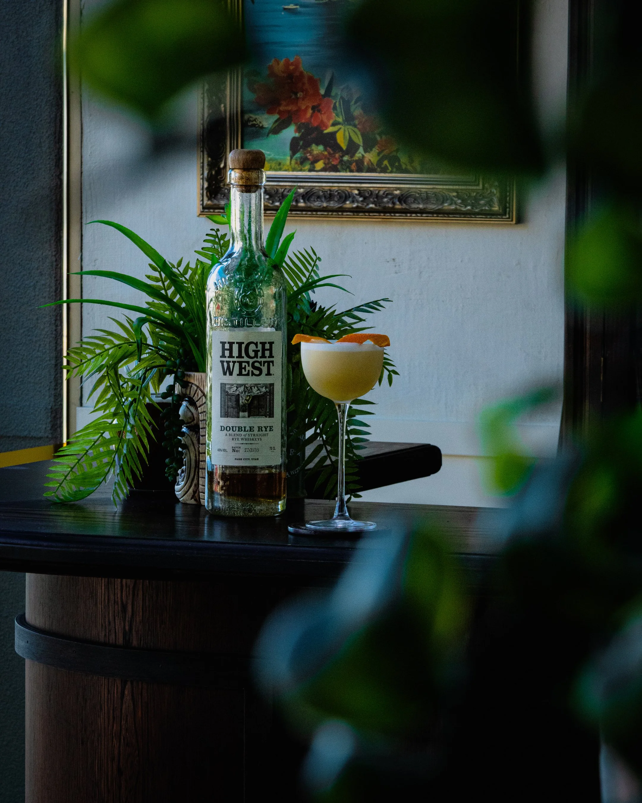 A whiskey sour, made from High West Whiskey & garnished with an orange twist, sat on a bar top.