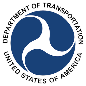 Logo of the United States Department of Transportation, featuring a white abstract symbol on a blue circle with black text around it.
