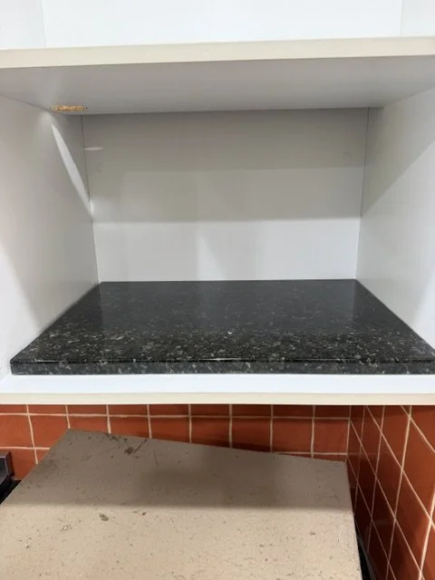 Microwave and cupboard mid cleaning.