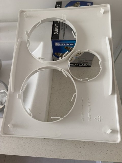 A dirty, dusty bathroom light and fan cover after cleaning