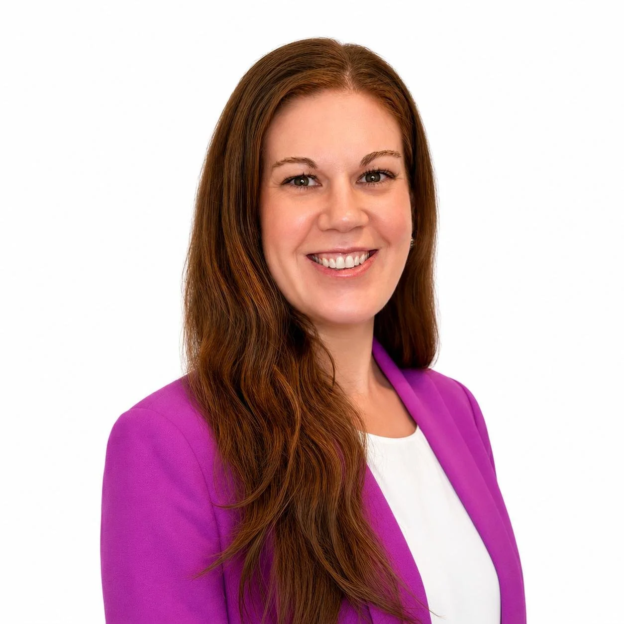 Headshot of a smiling woman with long red hair, wearing a purple blazer and white top, against a white background.