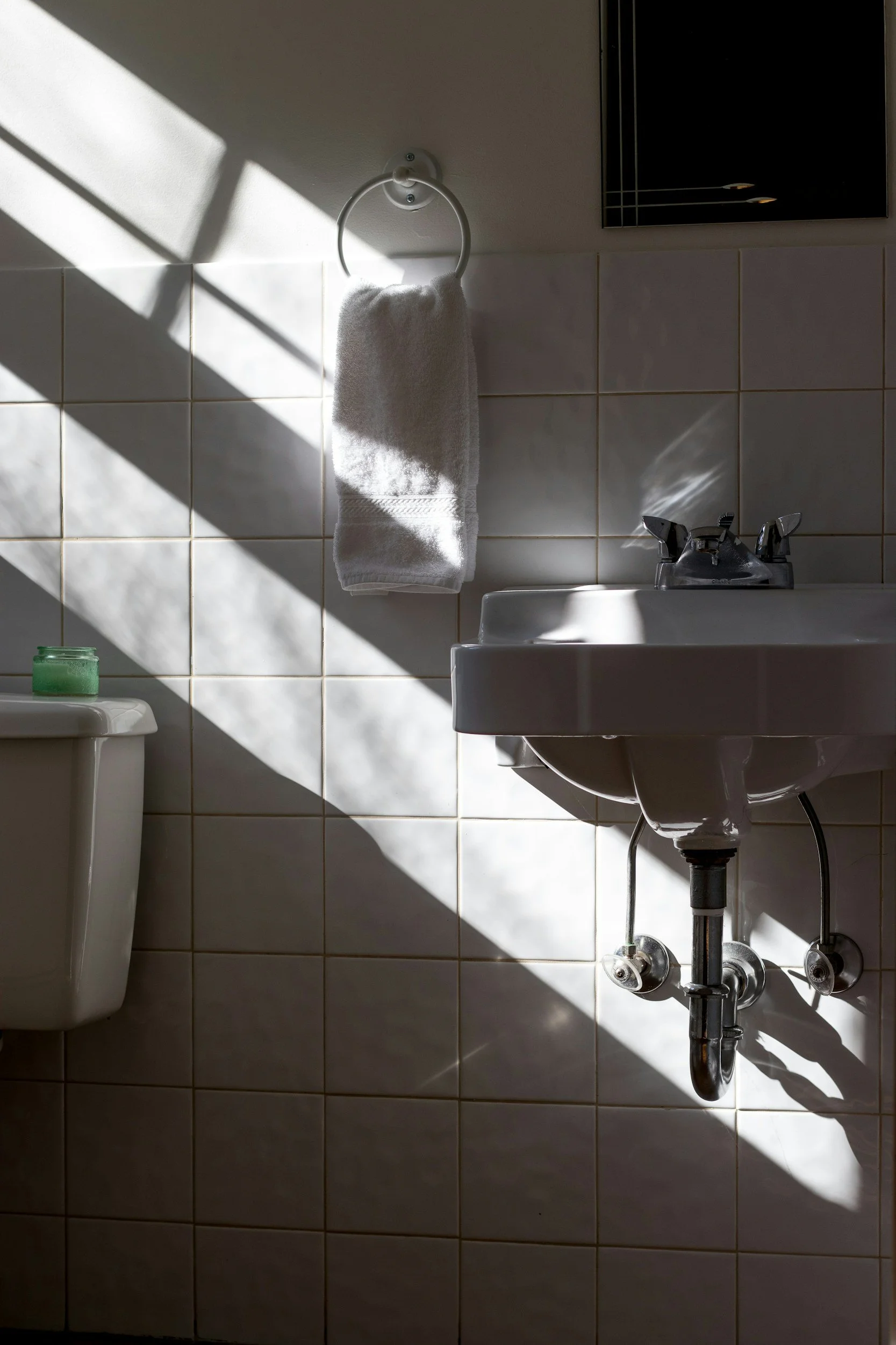 Wall hung basin and tapware in bathroom with white wall tiles