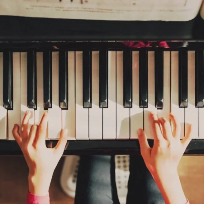 Hands playing a piano