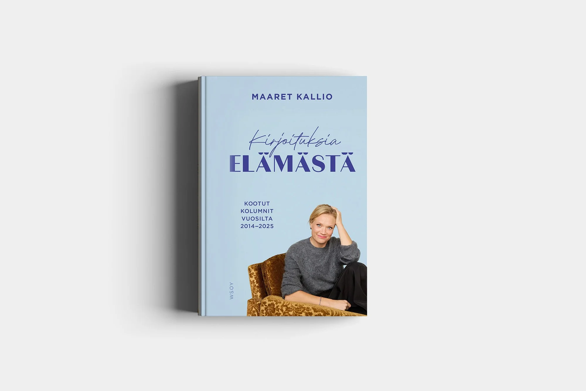 Kuvassa on kirja, jonka kannessa on nainen istumassa ja hymyilemässä. Kirjan nimi on "Kirjoituksia elämästä" ja on kirjoittanut Maaret Kallio.