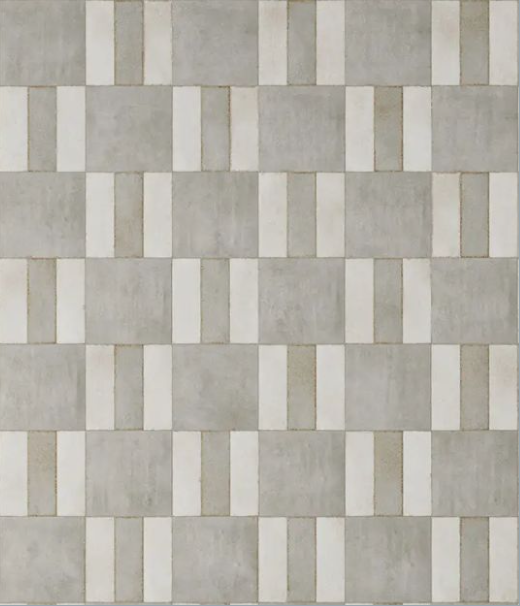 A wall with a pattern of rectangular light gray tiles and white grout lines.