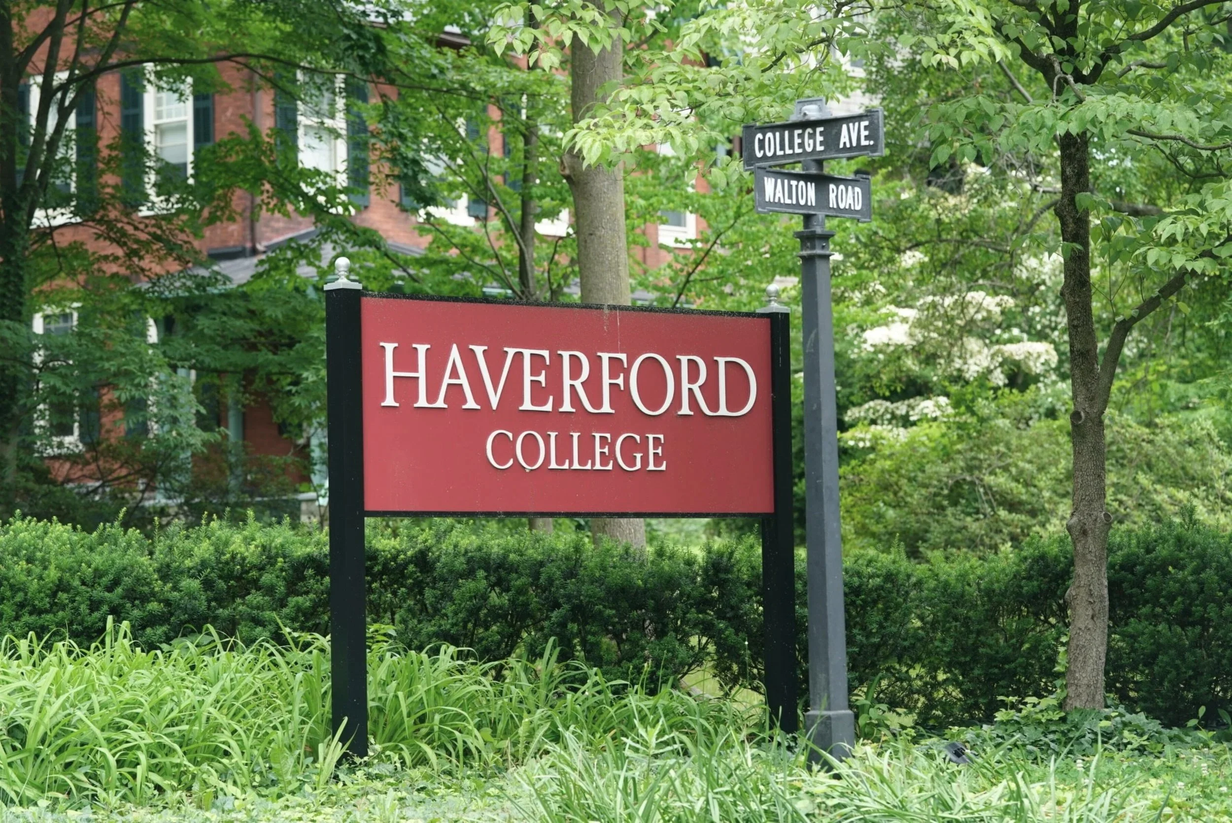 Street sign at College Avenue and Walton Road with a red Harvard College sign and trees in the background.
