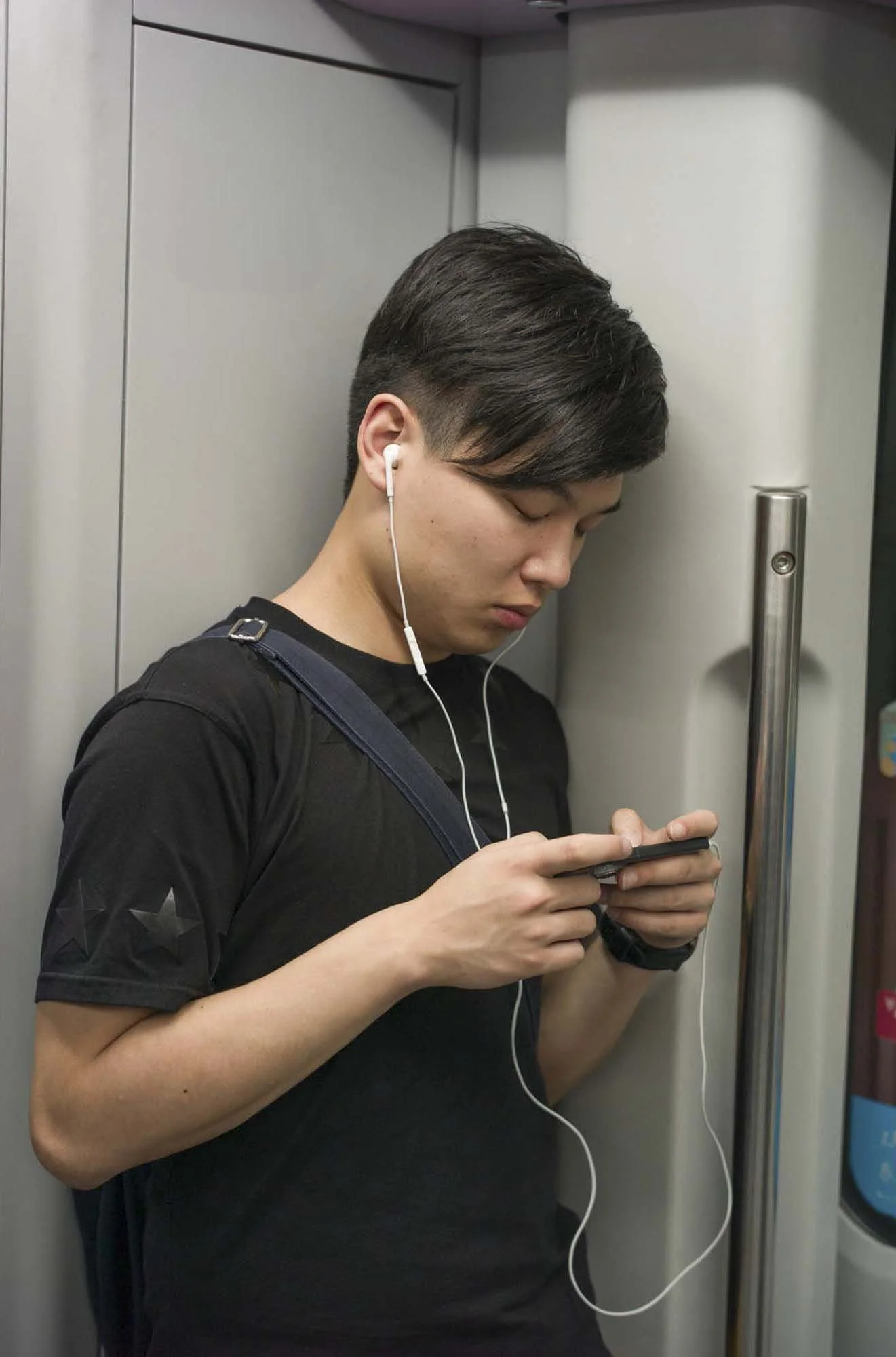 Submerged in thought, passengers in a Shanghai subway car gaze into their smartphones, photographed by Roman Bezjak