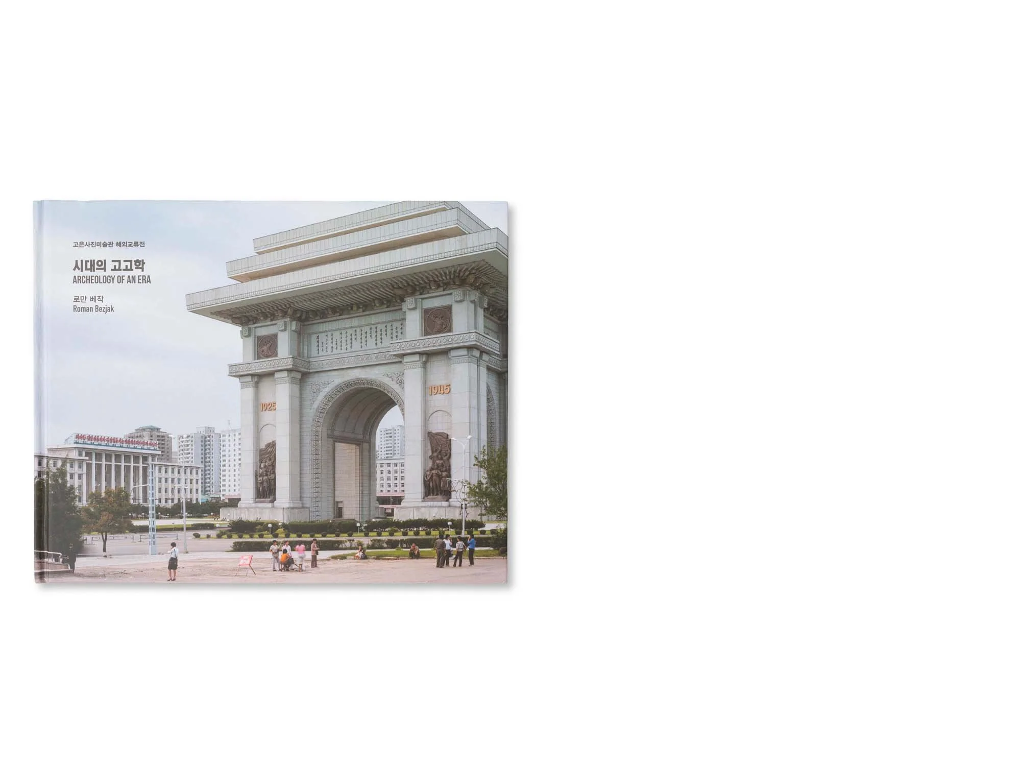 Ein Denkmal in Nordkorea mit einem großen Bogen und künstlerischen Reliefs, umgeben von Menschen und Hochhäusern.
