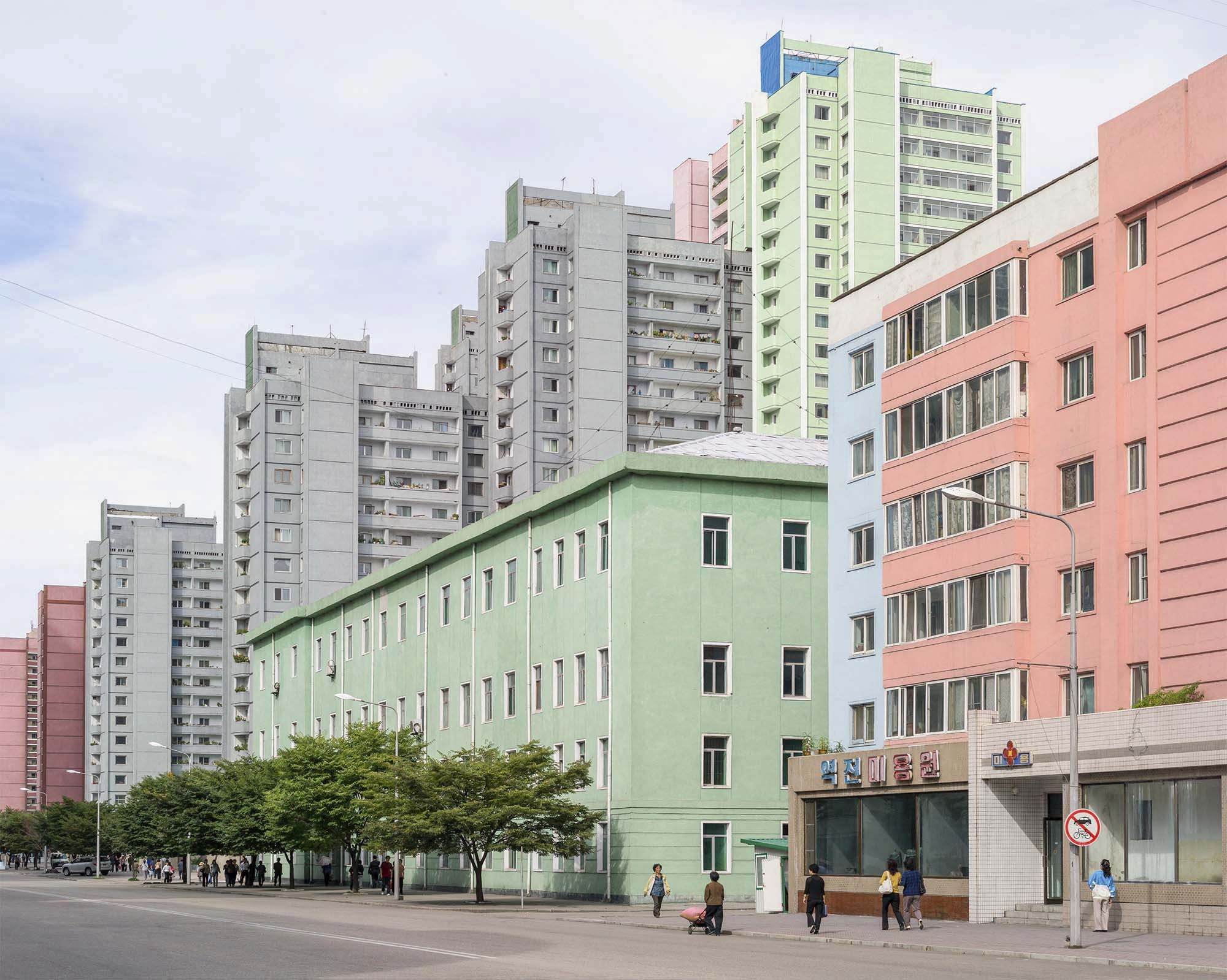 Pjöngjang, Nordkorea – Stadtansicht aus dem Zentrum der nordkoreanischen Hauptstadt mit farbenfrohen Wohnhäusern, modernen Hochhäusern und einer breiten Straße. Die typische Architektur und urbane Gestaltung vermitteln einen authentischen Eindruck vo